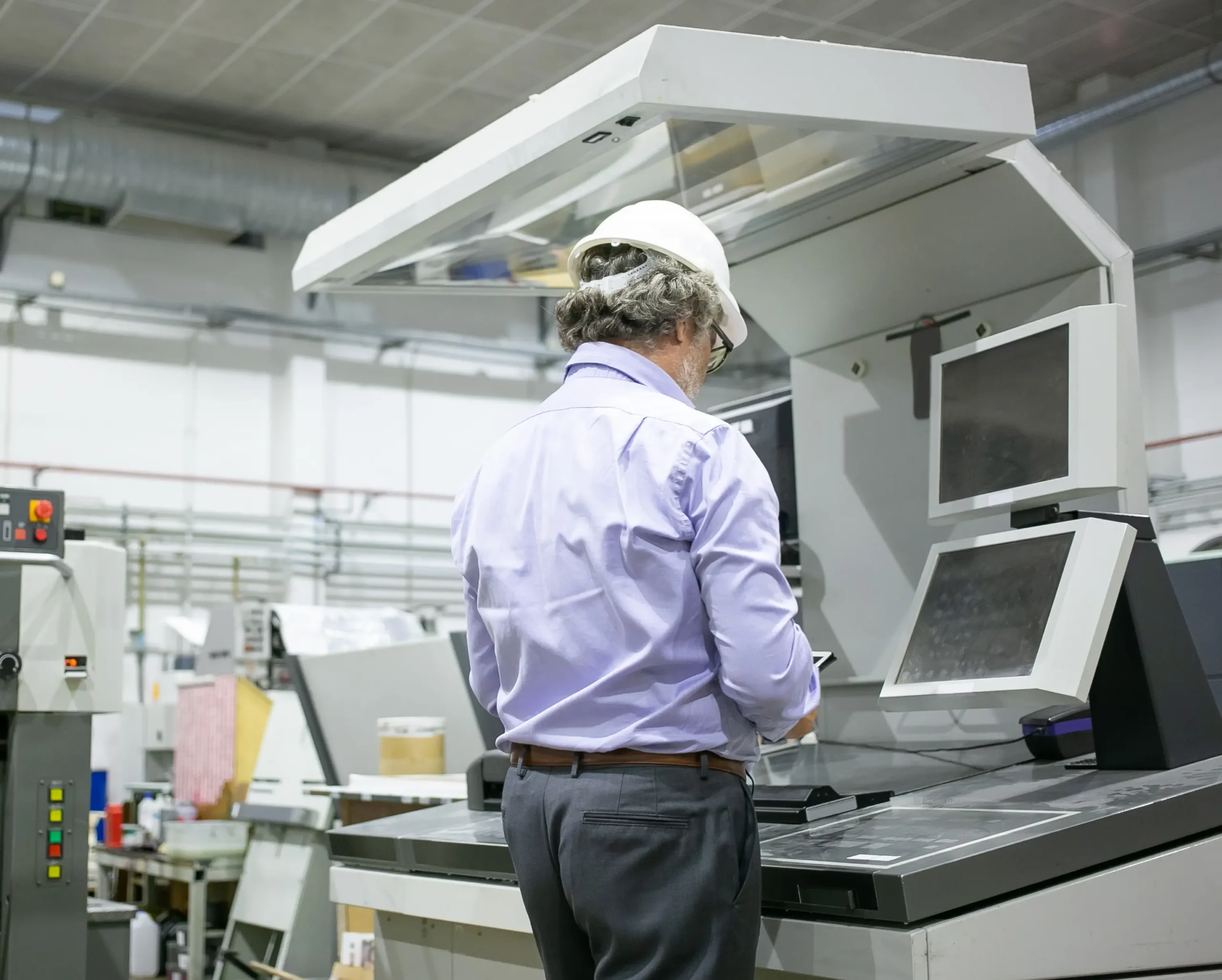 grey-haired-male-plant-engineer-hardhat-glasses-standing-industrial-machine-using-digital-device (1)